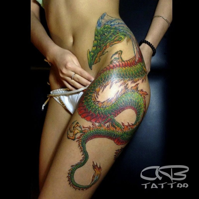 Тату дракона на бедре